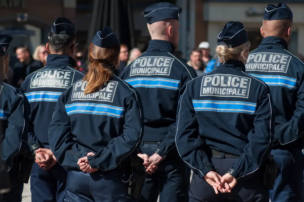 Policiers municipaux en uniforme, vus de dos, lors d’un exercice pratique dans le cadre de leur formation.