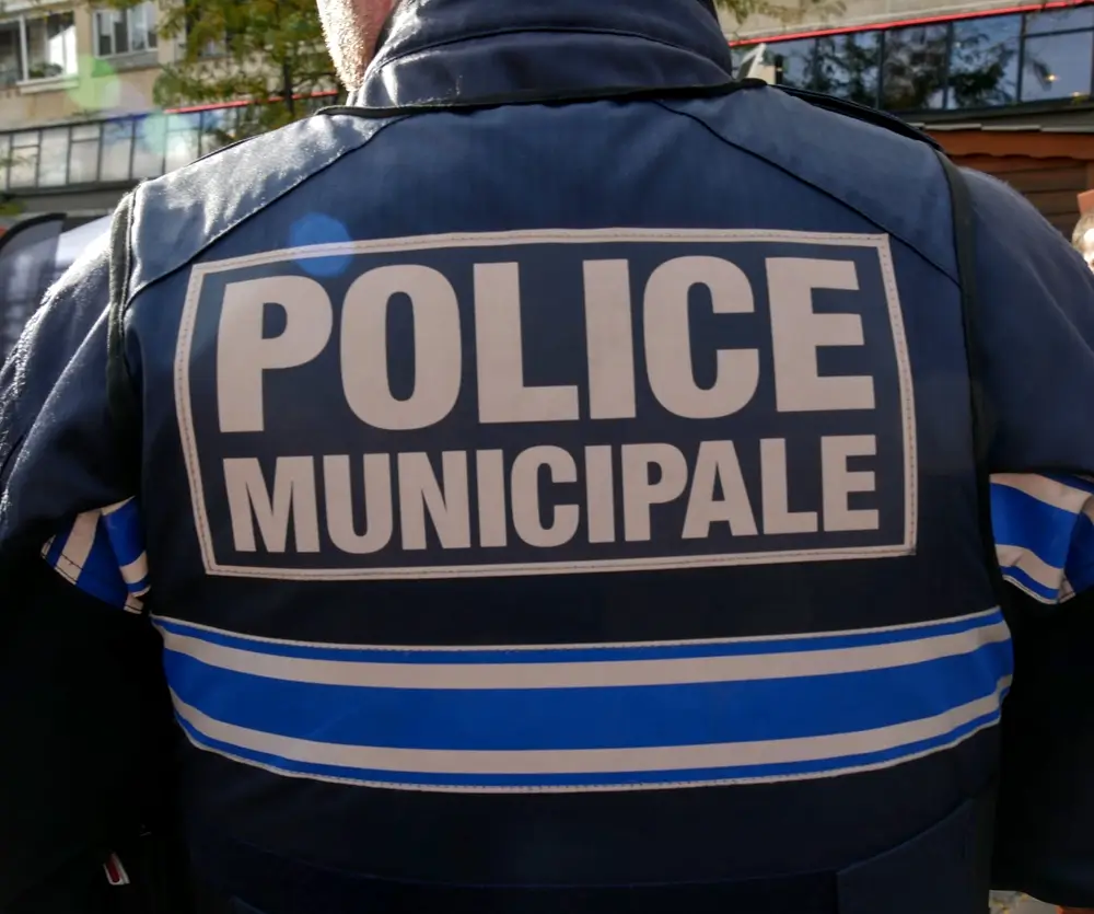 Insigne et marquage Police Municipale au dos de l'uniforme bleu d'un agent, illustrant l'accès à ce métier.