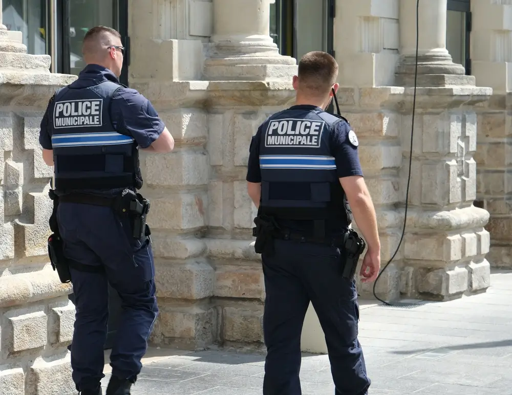 Policier municipal en uniforme patrouillant dans une rue de ville