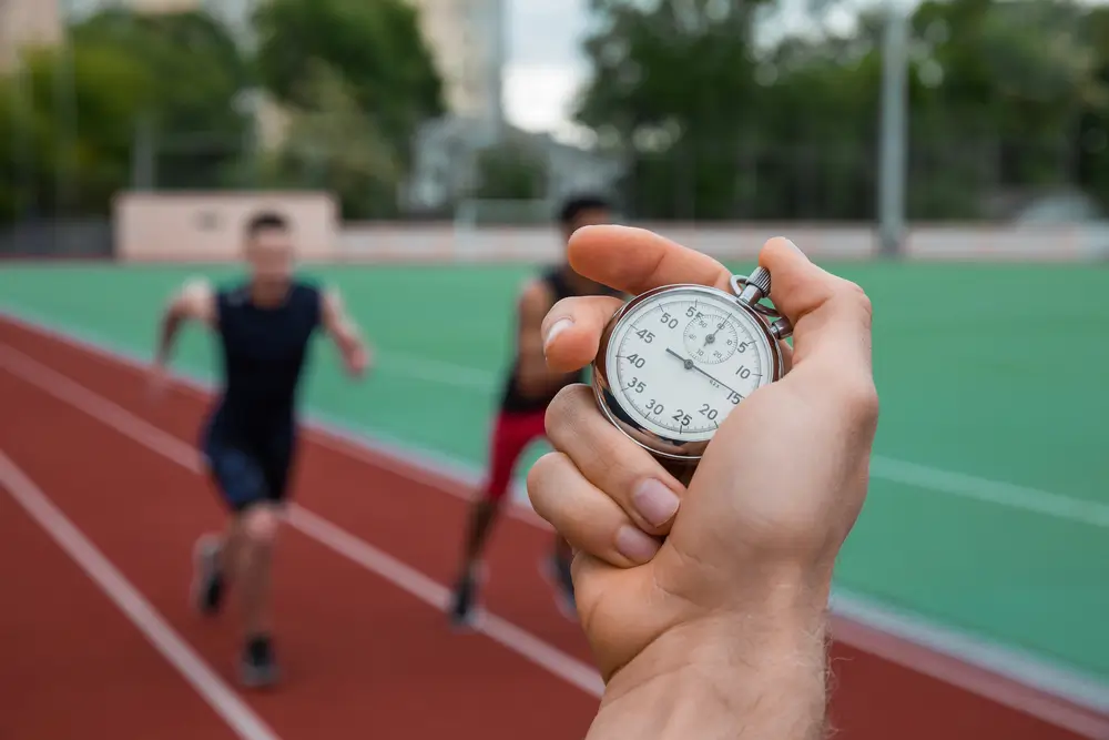 Chaussures de sport et chronomètre posés sur une piste d'athlétisme